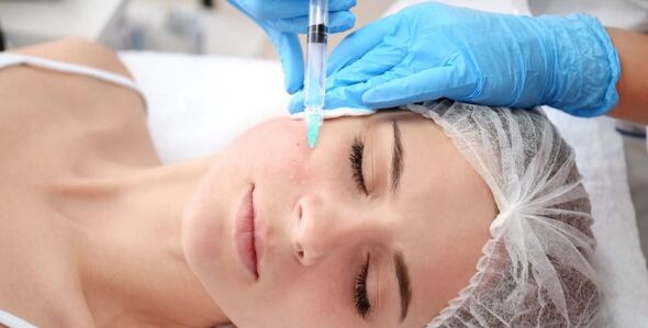 The cosmetologist performs the facial skin rejuvenation procedure with plasma